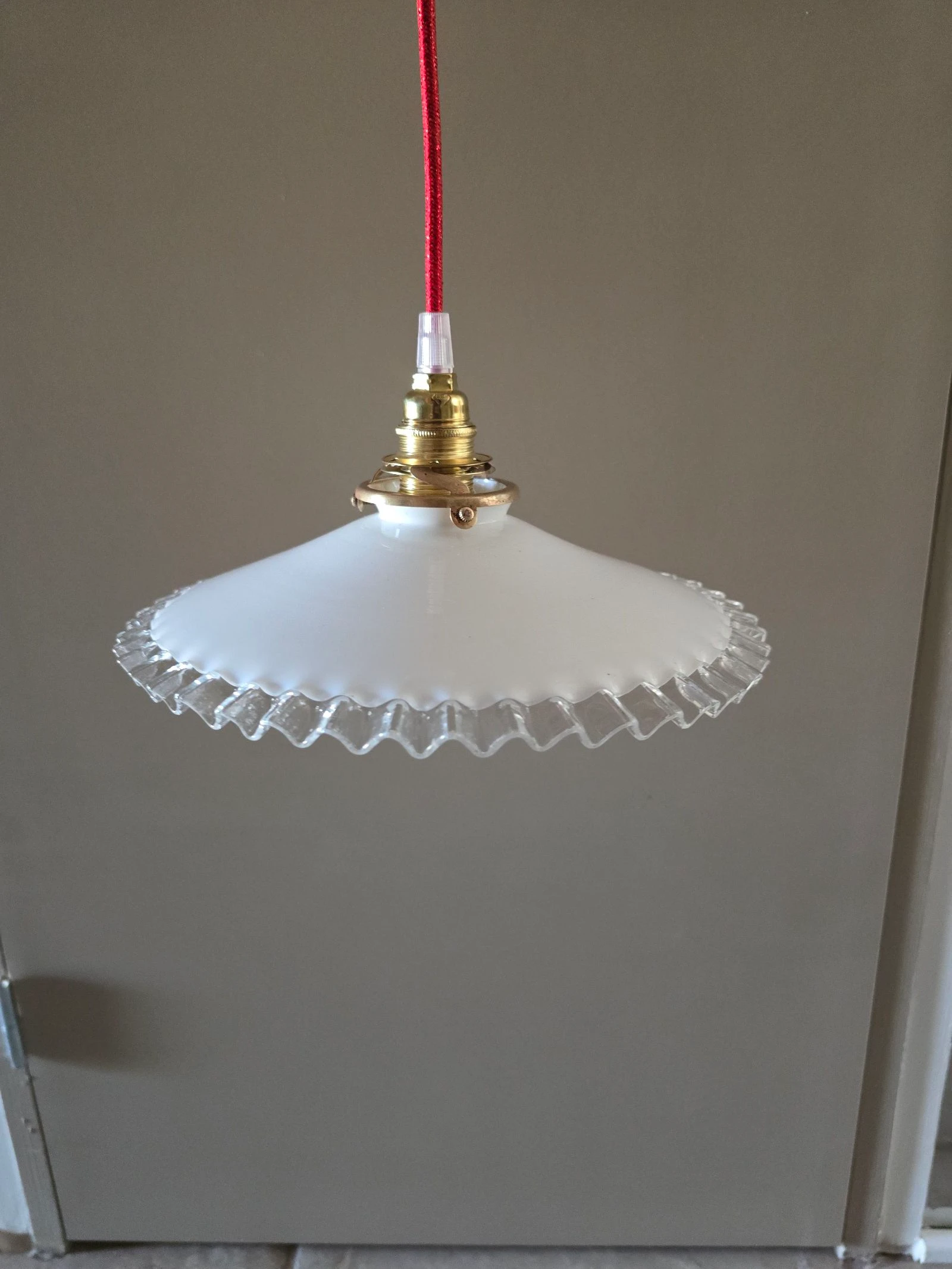 Suspension disque opaline blanche et bords transparents sur fil rouge et plafonnier en porcelaine